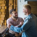 Two men engaged in conversation while sitting at a table in a restaurant